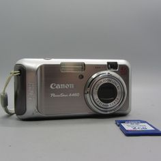 a silver digital camera sitting next to a card