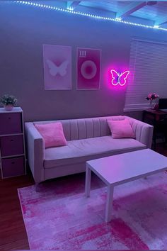 a living room filled with furniture and pink lighting on the ceiling above it's windows