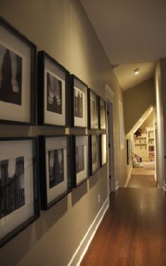 the hallway is lined with pictures and framed photographs