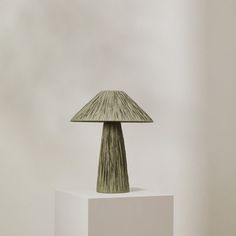 a green lamp sitting on top of a white block