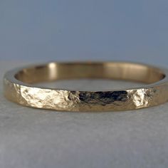 This personalized gold stacking ring has a rustic distressed finish that gives it a gentle timeworn vibe. The distressed finish gives the ring a subtle shine. Your inscription can go on the outside or the inside of this sweet little ring. Details Made from solid 14k yellow gold. 2mm wide and about 1.2mm thick. Rustic hammered finish Price includes an inscription of up to 14 characters.Available are uppercase letters A-Z, numbers 0-9, &, . , -, and a little heart symbol Important! The ring will b 14k Gold Hammered Stackable Promise Rings, Hammered 14k Gold Stackable Wedding Rings, 14k Gold Hammered Stackable Wedding Rings, Gold Hammered Stackable Rings For Anniversary, Hammered Stackable Round Band Rings As Gifts, Anniversary Yellow Gold Hammered Stackable Rings, Rustic Hand Forged Rings For Anniversary, Hand Forged 14k Gold Stackable Rings For Anniversary, 14k Gold Hand Forged Stackable Rings For Anniversary