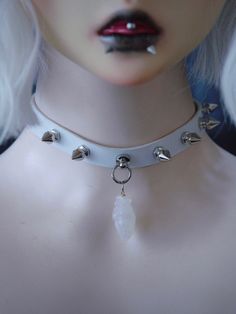 Elevate your gothic-inspired look with our heart pendant white gothic studs PU choker. This stunning choker features intricate stud detailing and a striking heart pendant, adding a touch of edgy romance to any outfit. The white PU material gives it a sleek and modern feel, while the adjustable design ensures a comfortable fit.   Please note that this product includes only the choker. Edgy Metal Choker For Cosplay, Alternative Metal Choker For Cosplay, Gothic Choker For Concert, Edgy Silver Choker For Cosplay, Silver Choker For Cosplay, Alternative Style Choker For Cosplay, Emo Alternative Fashion Choker, Emo Choker Jewelry For Concerts, Emo Choker Jewelry For Concert