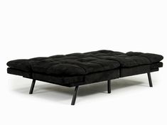 a black couch sitting on top of a white floor