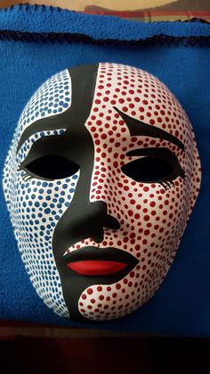 a mask is sitting on top of a blue cloth with polka dot pattern and black face