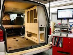 the back end of a van with its doors open and shelves in place for books