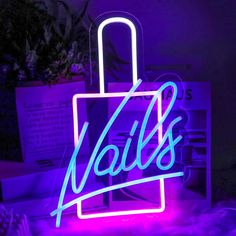 a neon sign with the word nails on it in front of a purple and blue background