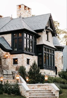 a large house with stone steps leading up to it's front door and windows