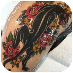 a woman's arm with an animal and flowers tattoo design on the back of her leg