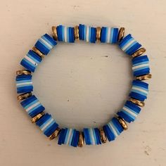 a blue and white beaded bracelet with gold accents