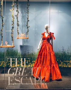 an orange dress is on display in a window