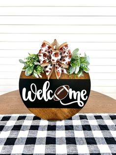 a welcome sign is sitting on top of a table with black and white checkered cloth