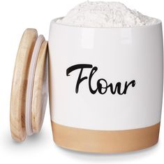 a white cup filled with flour next to a wooden lid