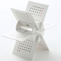 an origami calendar is displayed on a white surface