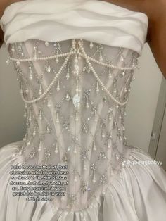 the back of a wedding dress with pearls on it