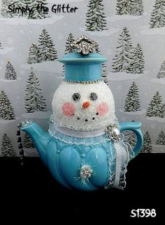 a blue teapot with a snowman on top