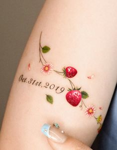 a woman's arm with a tattoo on it that says, love and cherries