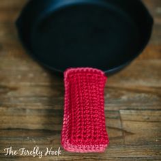 a red crocheted napkin sitting on top of a black pan