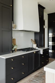 a kitchen with black cabinets and white counter tops