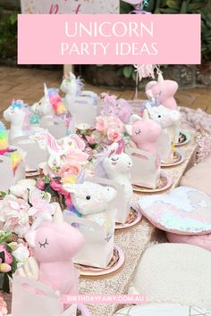 a table topped with lots of pink and white unicorn figurines on top of plates