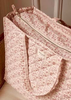 a pink floral bag sitting on top of a wooden table