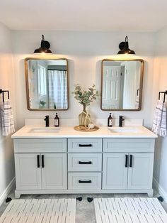 a bathroom with double sinks and two mirrors on the wall next to eachother