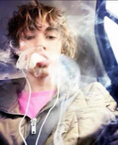 a young boy sitting in the back seat of a car with headphones attached to his ears