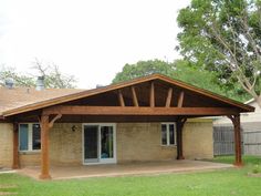 a covered patio in the back yard of a house