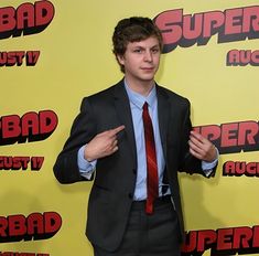 a young man in a suit and tie poses for the camera on the red carpet