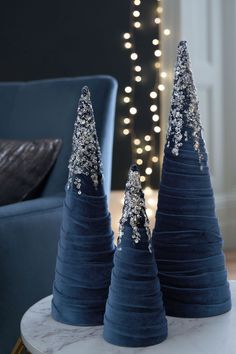 two blue christmas trees sitting on top of a table