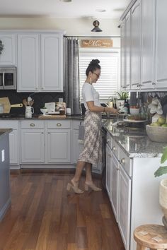 a woman standing in a kitchen preparing food on top of a wooden countertop next to an oven