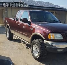 a red pick up truck parked in front of a building