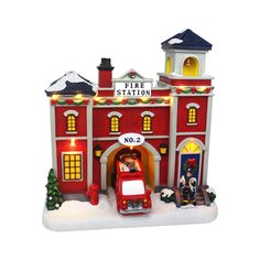 a toy fire station with a red car and christmas decorations on the front, and a white background