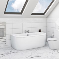 a white bathroom with two skylights above the bathtub, toilet and bidet