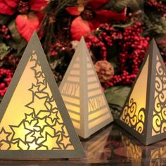 three paper christmas trees sitting on top of a table