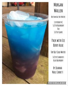 a blue drink with ice in it sitting on a wooden table next to a sign that says morgan wallen