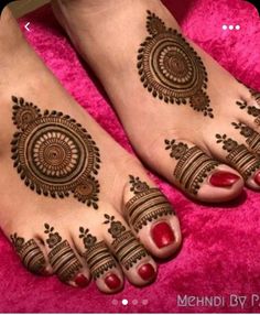 two feet with henna tattoos on them, one is red and the other is brown