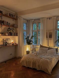 a bed in a room with lots of windows and plants on the wall next to it