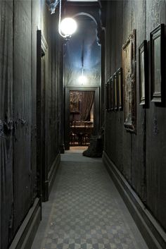 an empty dark hallway with checkered flooring