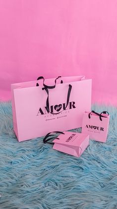 a pink shopping bag sitting on top of a blue fur covered floor next to a pair of scissors