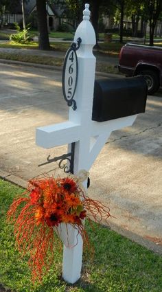 a white mailbox with an orange flower in it