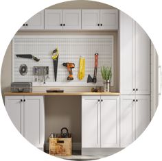 a kitchen with white cabinets and tools hanging on the pegboard in front of it