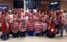 a group of people dressed up in red and white striped shirts posing for a photo