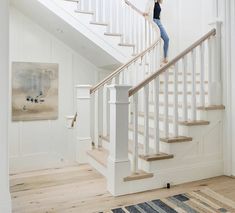 a woman is walking up the stairs in her home