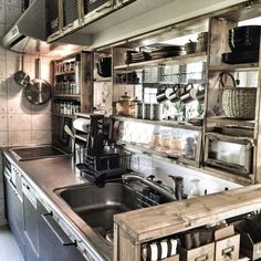 an industrial style kitchen with stainless steel appliances and wooden shelves filled with pots and pans