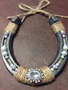 a necklace made out of leather and rope with pearls on the end, surrounded by other beads