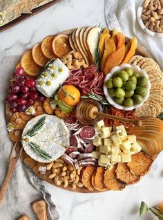 a platter filled with cheese, crackers and fruit