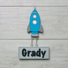 a blue and gray rocket ship shaped keychain with the word grady on it