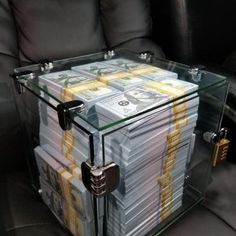 a stack of money sitting on top of a glass table next to a black couch