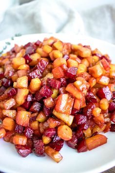 a white plate topped with cooked beets and cranberries