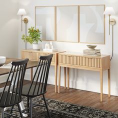 a dining room table with two chairs and a vase on top of it next to a wall mounted mirror